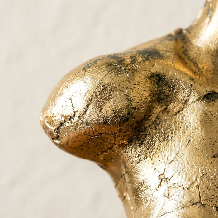 Macro detail of The Kore Fragment, gilded surface catching soft light